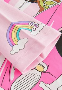 Rosa bomulls T-shirt med en regnbåge och moln grafik i pastellfärger, med djärva, tecknade designer och en mjuk textur.