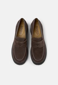 Brown suede loafers with a stitched accent and a textured black rubber sole. Features embossed "CAMPER" logo on the insole.