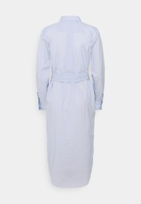 Světle modré pruhované šaty košilového střihu s dlouhými rukávy, páskem v pase, knoflíkovými manžetami a délkou do poloviny lýtek. Obsahují zadní yoke a sklady.