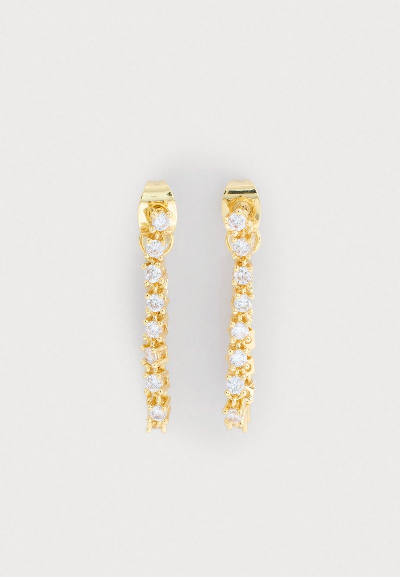 Guldfarvede øreringe med et strømlinet design, der har en række klare, rundskårne rhinsten langs en buet linje. Skinnende finish.