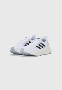Scarpe da corsa bianche con design a tre strisce nere, parte superiore in mesh traspirante, suola ammortizzata e suola in gomma testurizzata.