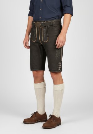 Pantalones cortos de cuero marrón con costuras decorativas, un cinturón ancho con hebilla de metal, combinados con calcetas de textura crema hasta la rodilla y zapatos marrones.