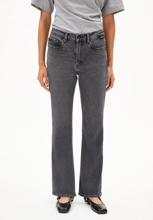 Black denim jeans with a straight cut, mid-rise waist, five-pocket design, and subtle faded texture. Worn with a gray t-shirt and black flats.