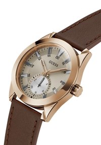 Round watch with a gold-tone stainless steel case, beige dial, brown leather strap, and sub-dial for seconds. Features silver accents and markers.
