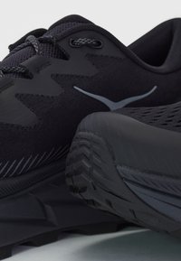 Juoksukengät mustana, joissa on hengittävä verkkomateriaali, teksturoidut ylikuoret ja kestävä kumipohja, jossa on monisuuntainen pito.