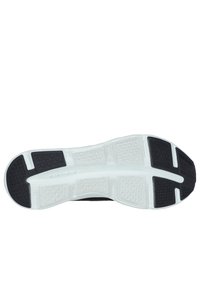 Suola di scarpa sportiva nera con un motivo di battistrada distintivo; una combinazione di materiali in gomma e schiuma; presenta elementi di ammortizzazione bianchi.