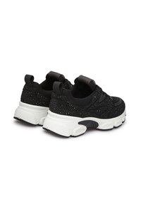 Scarpe sportive nere con una tomaia testurizzata decorata con strass, una suola bianca pronunciate e dettagli neri sul tallone e sulla linguetta.
