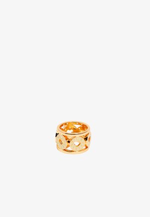 Gold-tone ring featuring circular cut-outs with heart shapes and engraved letters. Smooth, shiny finish with a wide band design.
