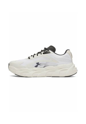Witte sportschoen met dikke zool, zwarte veters en zwart logo aan de zijkant, getoond vanuit het buitenprofiel op een witte achtergrond.