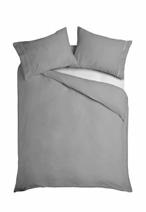 Lit double avec housse de couette gris clair et deux oreillers assortis, drap blanc partiellement visible sous la couette rabattue.