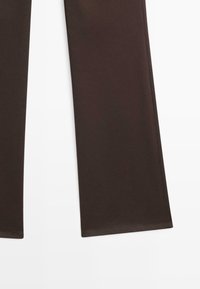 Brown leggings made from stretchy material; feature a smooth texture and a slim fit. Hem is finished with a simple, clean stitch.