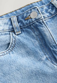 Light blue denim jeans featuring a faded wash, standard five-pocket design, metal button closure, and contrasting orange stitching.