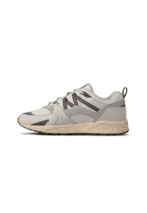 Witte en grijze sportschoen met beige gespikkelde zool, mesh- en suède-details, veters aan de voorkant en een hieltreklus die naar links wijst.