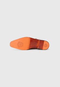 Suela de zapato de cuero marrón con una suela de color naranja. Presenta un logo grabado y acentos cosidos. Textura suave y forma afilada.