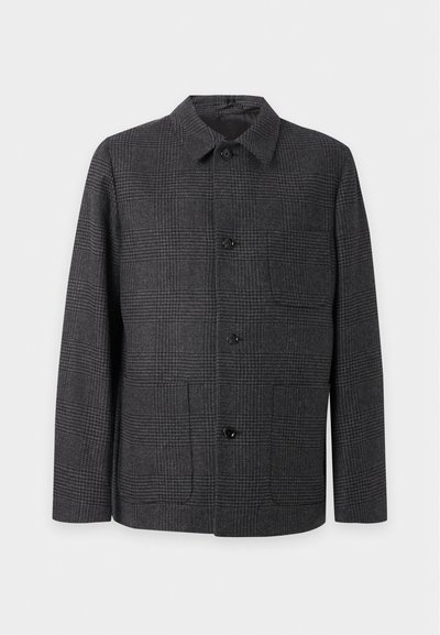 Veste à carreaux gris foncé avec col et quatre boutons devant, présentée sur un fond gris clair uni.
