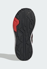 Đonji dio cipela s teksturiranom crnom gumom, s crvenim akcentom na strani i uzorkom na potplatu za bolje prianjanje.