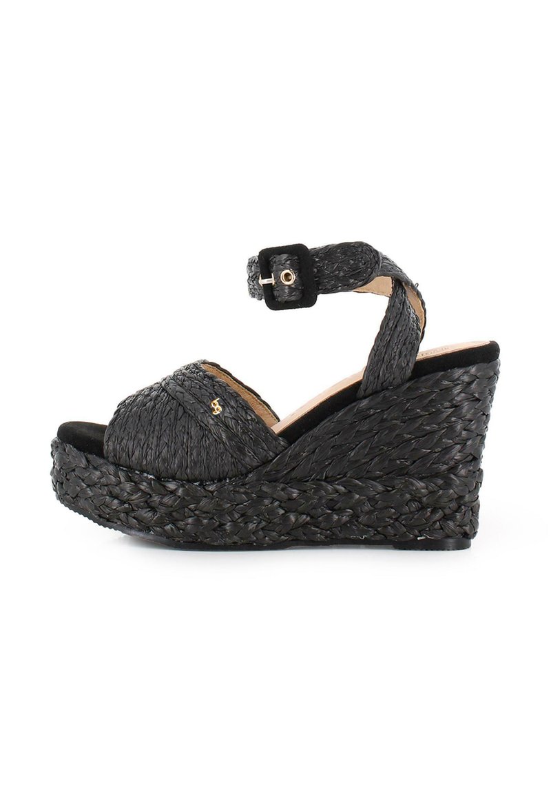 Sandalias de cuña tejidas en negro con una correa en el tobillo, que presentan un exterior texturizado y una suela de plataforma para mayor altura y comodidad.