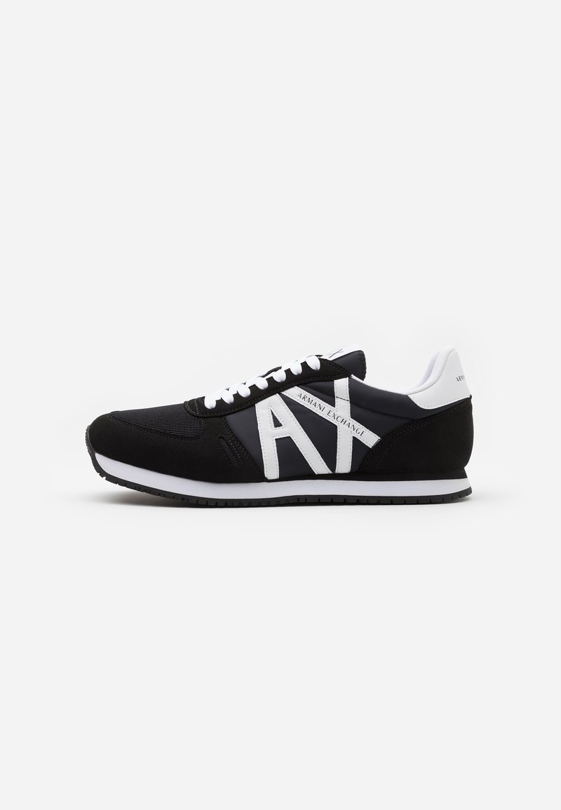 Czarne sportowe sneakersy z cholewką z siateczki i zamszu, z wyraźnym białym logo i sznurówkami oraz białą podeszwą środkową.