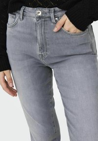 Šedé džíny z denimu s přiléhavým designem, vybavené přední kapsou, viditelným šitím a kovovým tlačítkem na zapínání v pase.