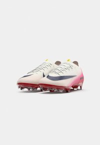 Paio di scarpini da calcio Nike Mercurial bianchi e rosa con swoosh nero e tacchetti traslucidi rossi su uno sfondo bianco.