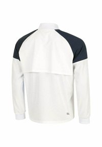 Chaqueta blanca de manga larga con una parte inferior texturizada y acentos en azul oscuro en los hombros. Presenta un cuello acanalado y una sutil marca.