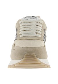 Baskets en suède beige avec une superposition texturée crème, lacets blancs, accents noirs sur le logo latéral et une semelle en caoutchouc.