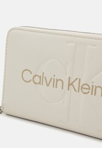 Calvin Klein Jeans SCULPTED ZIP AROUND MONO - Peňaženka - eggshell