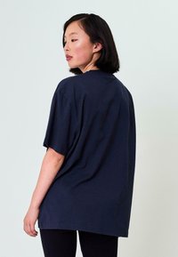 Mer navy oversized t-paita, jossa on lyhyet hihat ja pyöreä kaula-aukko, rento istuvuus ja sileä tekstuuri.