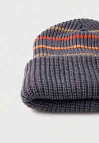 Harmaa neulottu pipo, jossa oransseja, keltaisia ja harmaita vaakaraitoja. Valmistettu pehmeästä kankaasta, jossa on resorikuvio.