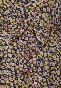 Vestido floral em preto com flores rosas e amarelas, apresentando uma cintura ajustada com laço, frente com botões e tecido leve texturizado.