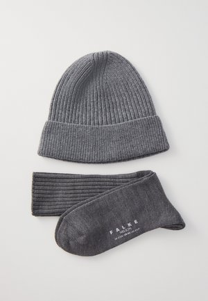 Grau gestrickte Mütze mit geripptem Design und Umschlag, kombiniert mit passenden gerippten Beinstulpen und Socken, die ein weißes Markenlogo tragen.