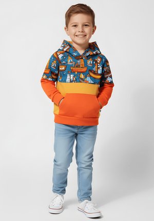 Bluza z kapturem z niebieskim motywem morskim, pomarańczowymi rękawami i żółtym panelem. Połączona z jasnoniebieskimi dżinsami i białymi trampkami.