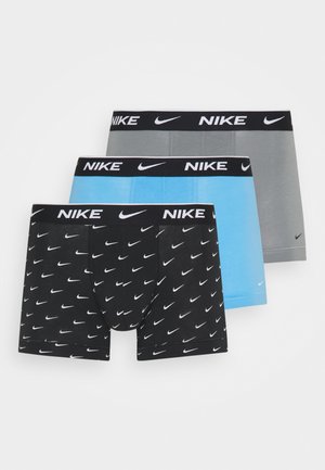 Trois paires de boxers pour hommes, en noir avec un motif de logo blanc, bleu clair et gris. Chacune a une ceinture noire avec le texte "NIKE".