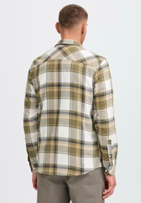 Groen en wit geruit shirt met lange mouwen, voorzien van een knoopmanchet, puntige kraag en een afgeronde zoom. Gemaakt van een katoenmix.