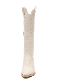 Białe skórzane kowbojskie buty z wydłużonym noskiem, dekoracyjnym przeszyciem i falbaniastą górną krawędzią. Posiadają zamek błyskawiczny z boku i niski obcas.