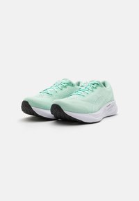 Licht mintgroene sportschoenen met een ademend mesh bovenwerk, platte veters en een witte tussenzool; gestructureerde zwarte rubberen buitenzool voor grip.