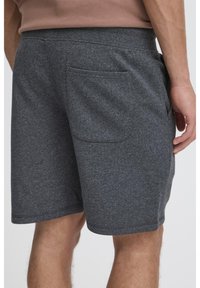 Pantaloncini in misto cotone grigio con cintura elastica, tasche laterali e una sola tasca posteriore. Tessuto morbido e vestibilità comoda.