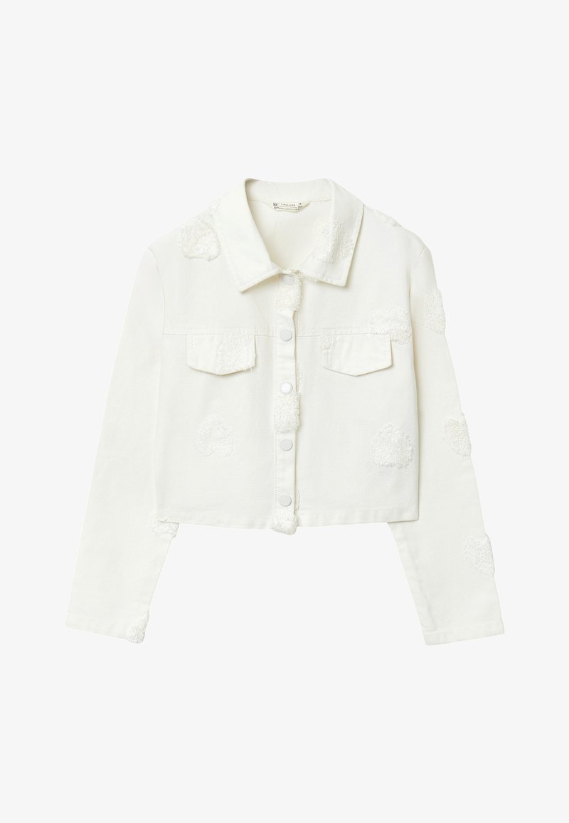Veste en denim blanche raccourcie avec col, poches avant et patchs texturés. Elle possède des boutons-pression en métal et une finition texturée et douce.