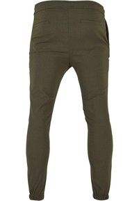 Olijfgroene tapered joggers van een textuurstof, met elastische boorden en twee achterzakken. Glad oppervlak zonder zichtbare patronen of hardware.