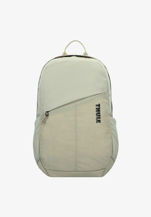 Helles grauer Rucksack aus glattem Stoff, mit einer vorderen Reißverschlusstasche und dem schwarzen Thule-Logo. Abgerundete Oberseite und seitliche Netztaschen.