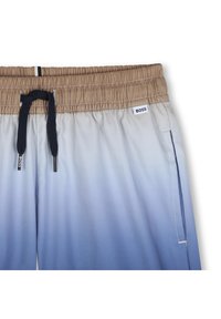 Ελαφριά μαγιό σορτς με διαβάθμιση από μπεζ σε ανοιχτό μπλε, ελαστική μέση, κορδόνια και πλαϊνή τσέπη. Ο ρατό λογότυπο.