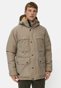 Beige isolierte Jacke mit Kapuze, mehreren Fronttaschen, schwarzen Knöpfen und einem weichen Innenfutter. Verfügt über einen stabilen Reißverschluss.