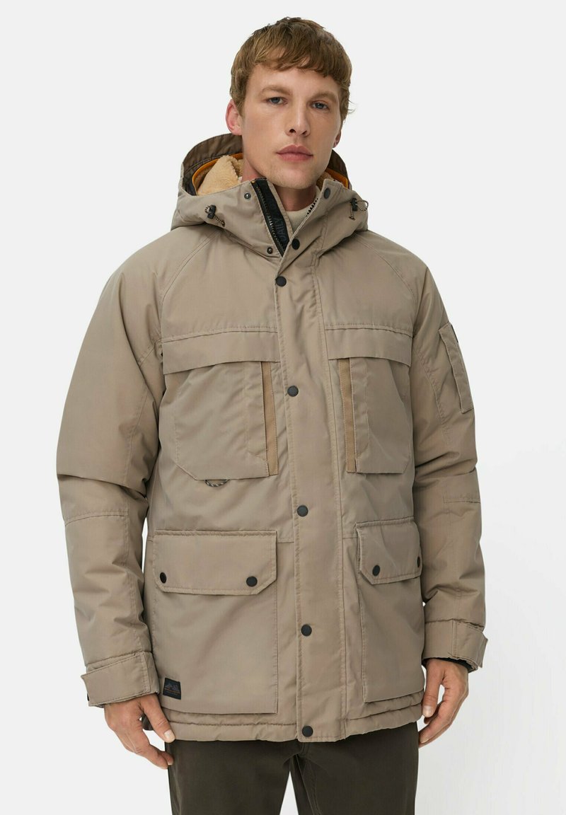 Beige isolierte Jacke mit Kapuze, mehreren Fronttaschen, schwarzen Knöpfen und einem weichen Innenfutter. Verfügt über einen stabilen Reißverschluss.