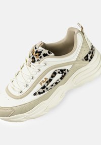 Sneaker bianca e beige con pelle texturizzata e dettagli in stampa leopardata. Presenta un logo dorato, design con lacci e una suola chunky per il supporto.