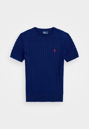 Pull en maille torsadée bleu marine à manches courtes avec poignets et ourlet côtelés, présentant un petit logo rouge brodé sur la poitrine.