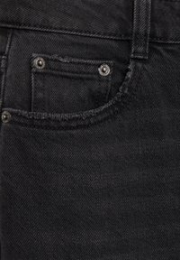 Gros plan d'un jean en denim noir montrant une petite poche avant avec des rivets en métal et des détails de couture visibles.