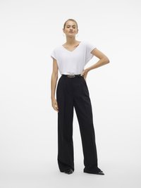 Tricou alb cu decolteu în V și mâneci scurte, asortat cu pantaloni negri cu talie înaltă, având un curea cu o cataramă ovală aurie.