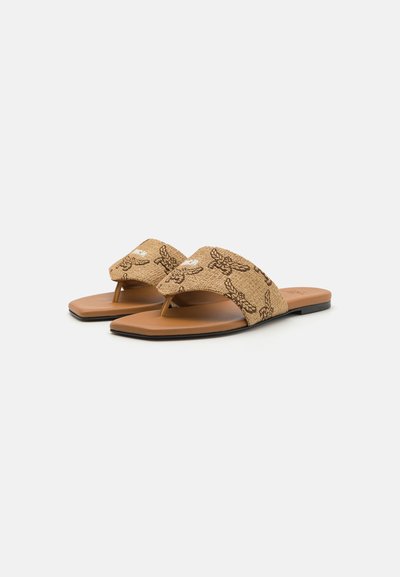 Sandales plates beiges avec une sangle en tissu texturé ornée d'un motif floral sombre et une semelle en caoutchouc. Design minimaliste et style ouvert à l'avant.