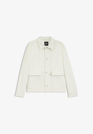 Veste boutonnée blanc cassé avec deux poches à rabat sur le devant, un col et des manches longues, étiquetée BOSS à l’intérieur du col.