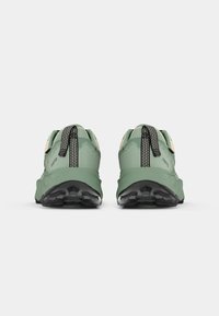 Green athletic shoes with black rubber soles, featuring a textured fabric upper and black accents. Includes pull tabs for easy wear.